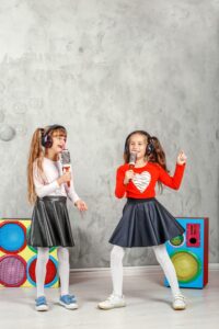 Happy children sing and listen to music in headphones. The conce