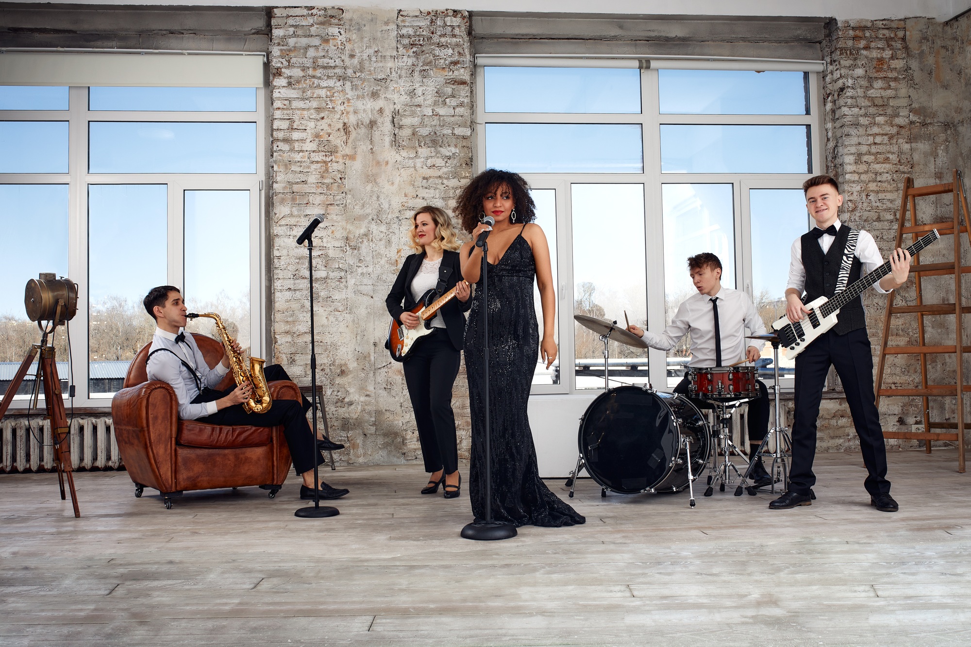 Repetition of multi ethnic jazz band in loft. Bass guitar player, electric guitar player